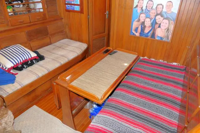 Slide: The Image of Cozy interior of 1978 Brewer 45 Ketch with wooden furnishings and striped bedding. - 3