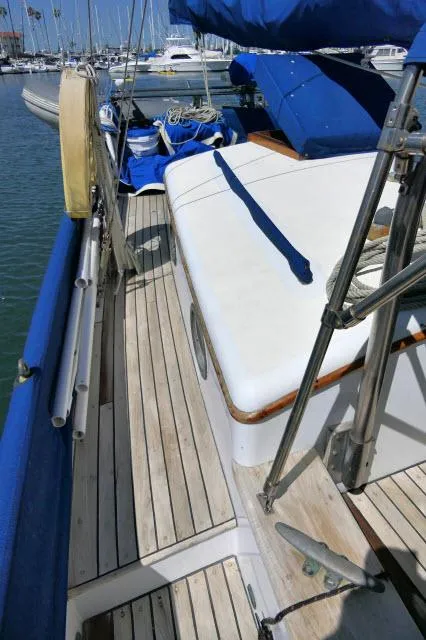 Slide: The Image of 1978 Brewer 45 Ketch sailboat deck with blue covers in marina setting. - 30