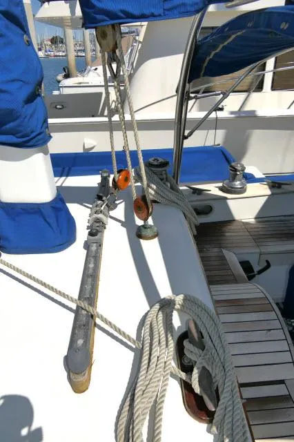 Slide: The Image of 1978 Brewer 45 Ketch deck with ropes, winches, and blue covers. - 35