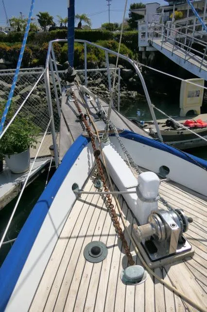 Slide: The Image of 1978 Brewer 45 Ketch sailboat deck with anchor chain and winch in marina. - 39