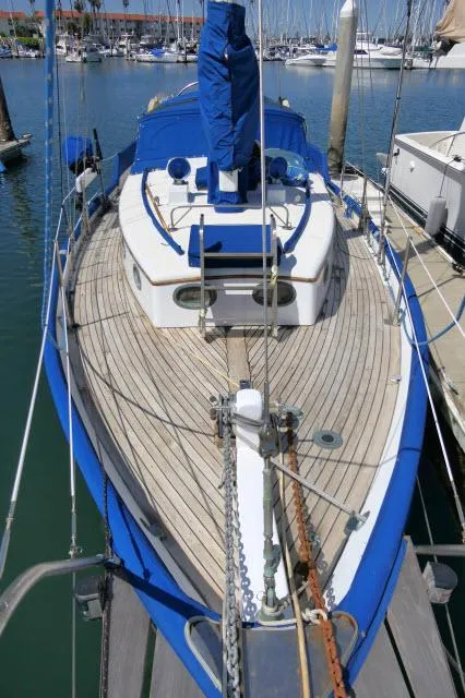 Slide: The Image of 1978 Brewer 45 Ketch sailboat docked in marina, featuring blue and white deck design. - 40