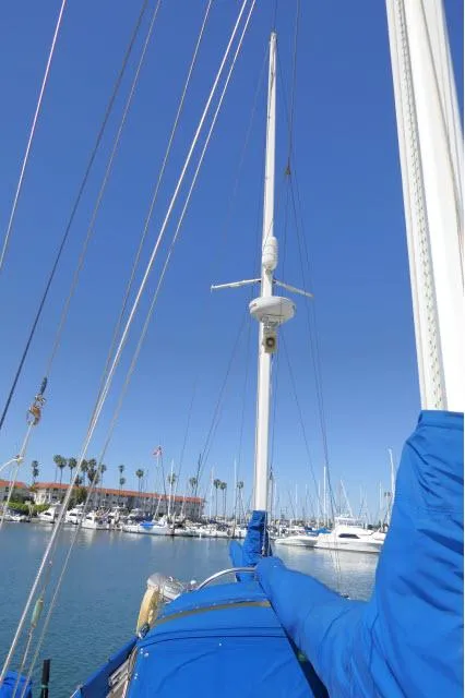 Slide: The Image of 1978 Brewer 45 Ketch sailboat in marina, blue sky, masts, and rigging visible. - 41