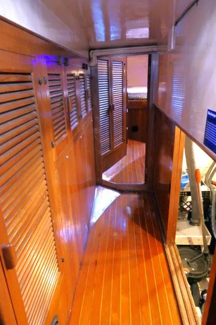 Slide: The Image of Interior hallway of a 1978 Brewer 45 Ketch with wooden paneling and flooring. - 44