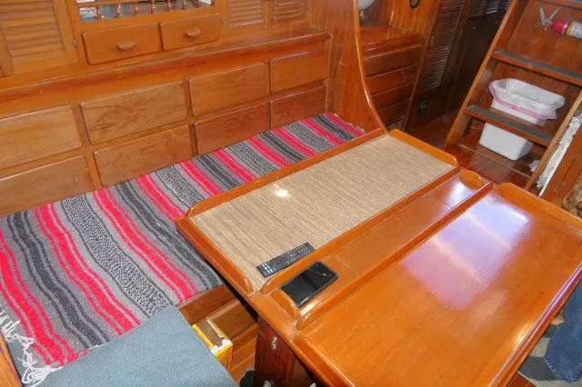 Slide: The Image of Interior of 1978 Brewer 45 Ketch with wooden cabinetry and colorful striped blanket. - 5
