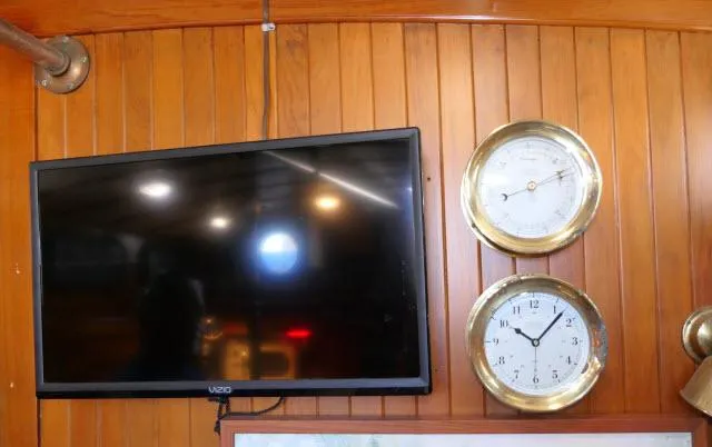 Slide: The Image of Wall-mounted TV and clocks on a 1978 Brewer 45 Ketch yacht interior. - 6