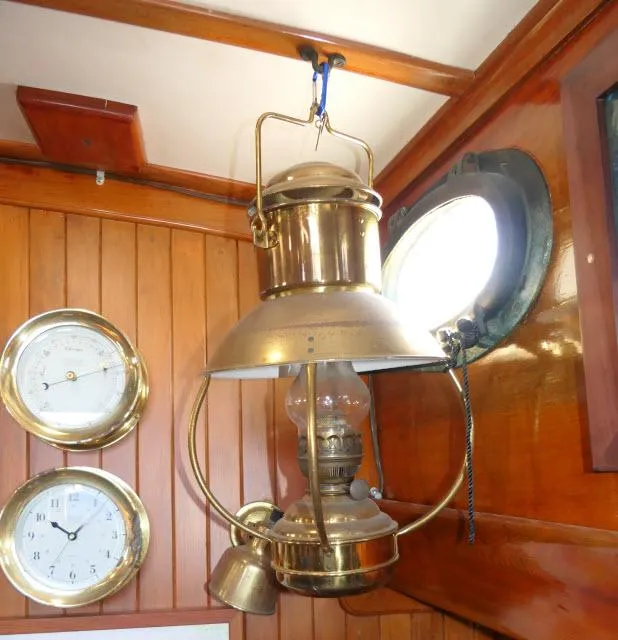Slide: The Image of Vintage brass lantern and clocks inside a 1978 Brewer 45 Ketch sailboat cabin. - 7