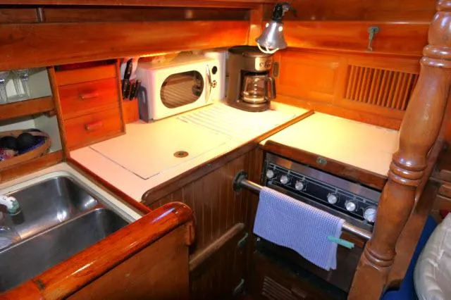 Slide: The Image of 1978 Brewer 45 Ketch galley with stove, microwave, and coffee maker. - 8