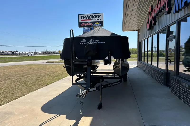 Slide: The Image of 2023 Sun Tracker BB 18 DLX boat covered, parked outside dealership. - 12