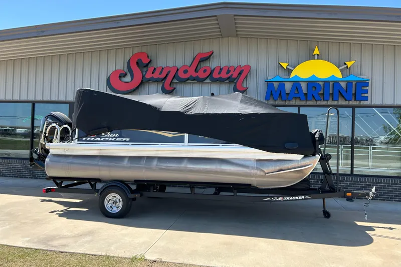 Slide: The Image of 2023 Sun Tracker BB 18 DLX pontoon boat covered, parked at Sundown Marine dealership. - 13