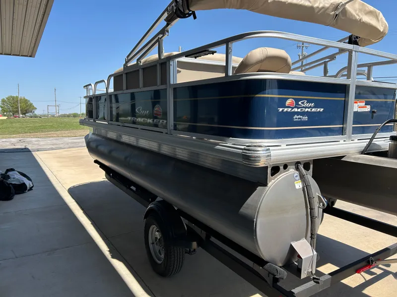 Slide: The Image of 2023 Sun Tracker BB 18 DLX pontoon boat on trailer, parked outdoors. - 4