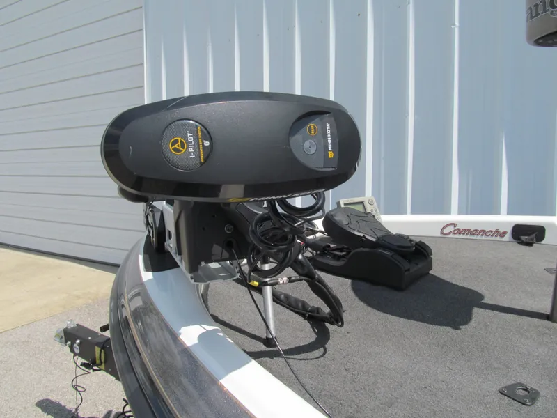 Slide: The Image of 2005 Ranger 185 VX boat with trolling motor on deck, parked near a building. - 13