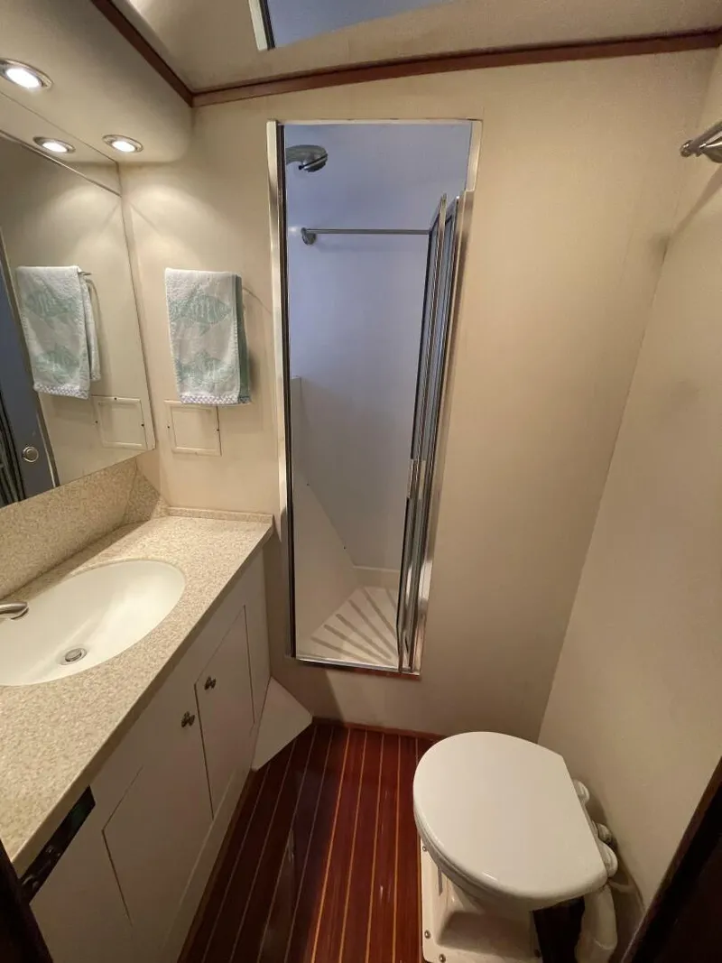 Slide: The Image of 1985 Hatteras Enclosed Bridge yacht bathroom with sink, shower, and toilet. - 14