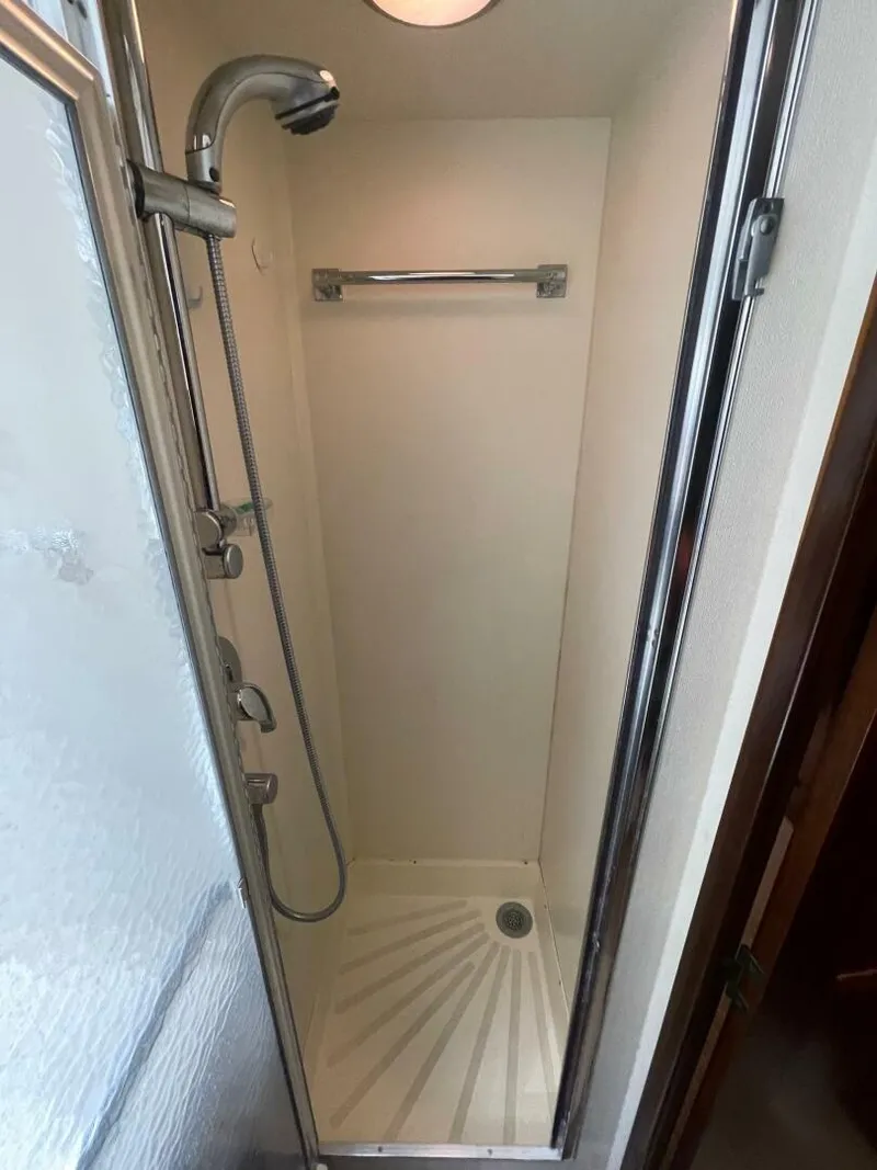 Slide: The Image of Compact shower in 1985 Hatteras Enclosed Bridge yacht, featuring modern fixtures and sleek design. - 20