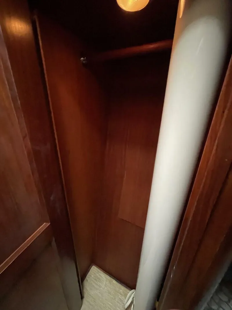 Slide: The Image of 1985 Hatteras Enclosed Bridge interior closet with wooden finish and lighting. - 23