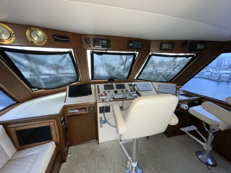 Slide: The Image of 1985 Hatteras Enclosed Bridge helm with navigation equipment and panoramic windows. - 24