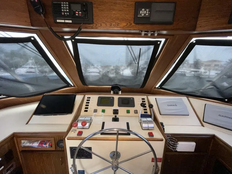 Slide: The Image of 1985 Hatteras Enclosed Bridge helm with navigation equipment and steering wheel. - 26