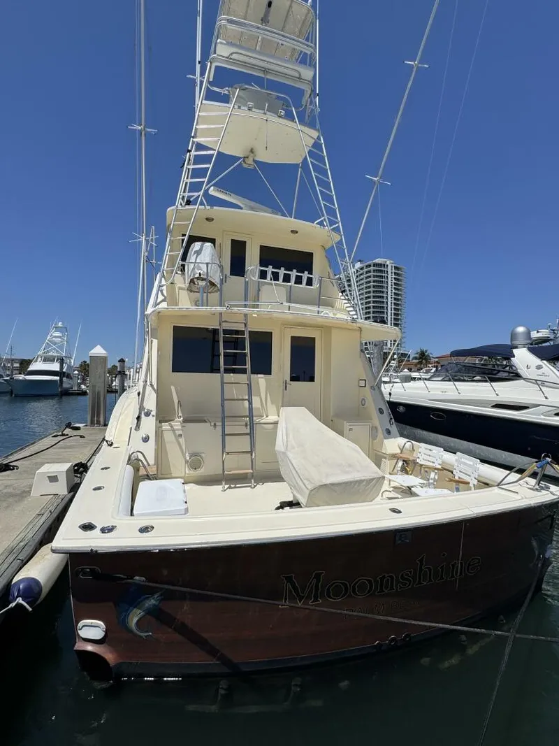 Slide: The Image of 1985 Hatteras Enclosed Bridge yacht docked at marina under clear blue sky. - 29