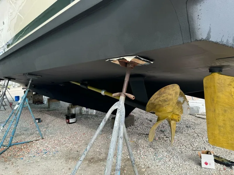 Slide: The Image of 1985 Hatteras Enclosed Bridge boat under maintenance, showing propeller and hull details. - 38