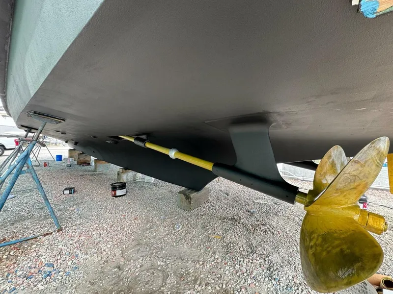 Slide: The Image of 1985 Hatteras Enclosed Bridge boat underside with propeller and support stands. - 39