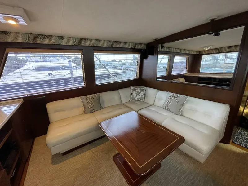 Slide: The Image of Luxurious 1985 Hatteras Enclosed Bridge yacht interior with plush seating and elegant wood table. - 4