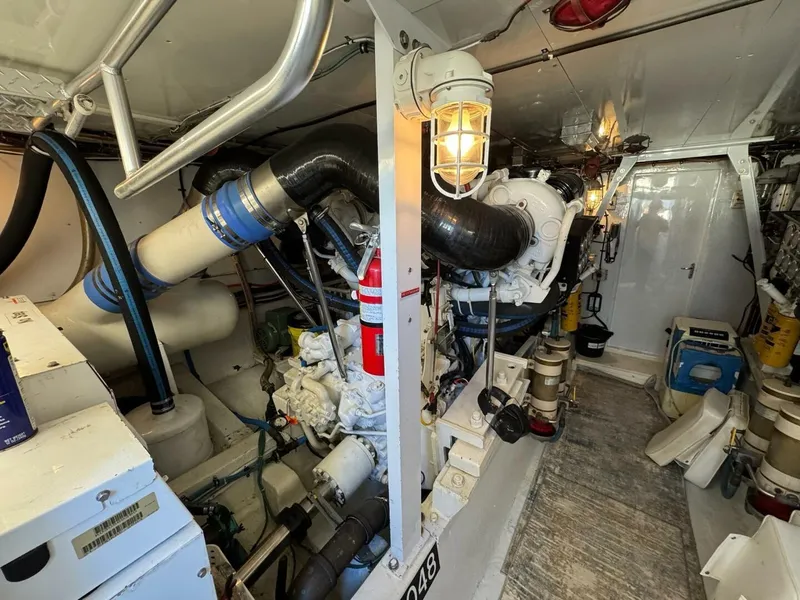 Slide: The Image of Engine room of a 1985 Hatteras Enclosed Bridge yacht, featuring machinery and safety equipment. - 42