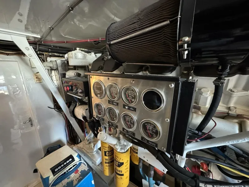 Slide: The Image of Engine room of 1985 Hatteras Enclosed Bridge with control panel and gauges. - 45