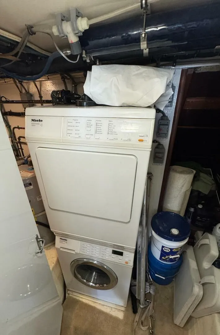 Slide: The Image of Laundry area inside a 1985 Hatteras Enclosed Bridge yacht with stacked washer and dryer. - 49