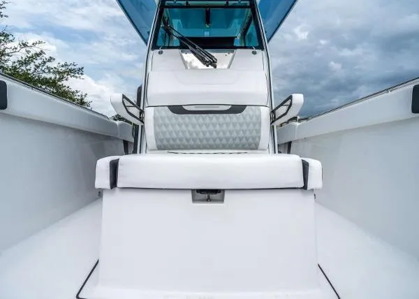Slide: The Image of 2024 Blackfin 272 boat interior with white seating and blue canopy under cloudy sky. - 11
