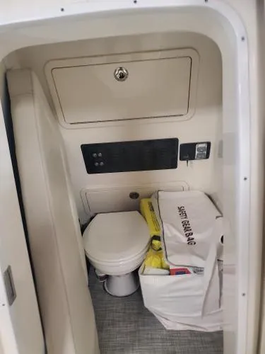 Slide: The Image of 2023 World Cat 260 CC-X boat interior with compact toilet and storage area. - 12