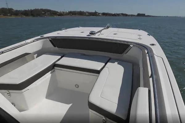 Slide: The Image of 2023 World Cat 260 CC-X boat interior with cushioned seating on calm water. - 13