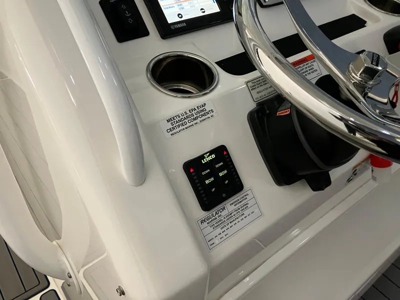 Slide: The Image of Control panel of a 2013 Regulator 28 boat, featuring steering wheel and electronic controls. - 13