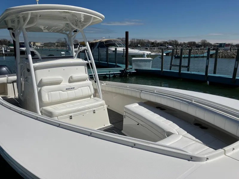 Slide: The Image of 2013 Regulator 28 boat with white seating, docked at a marina under clear skies. - 16