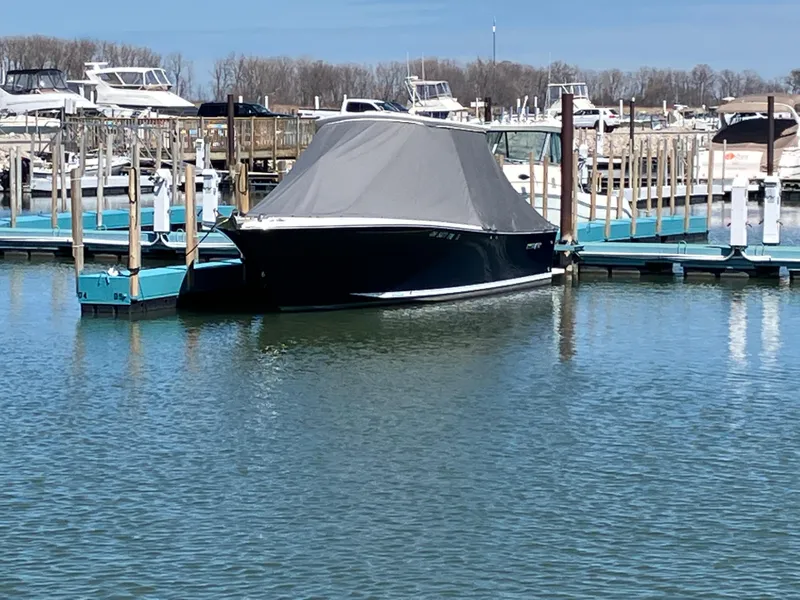 Slide: The Image of 2013 Regulator 28 boat docked with cover in a marina. - 2