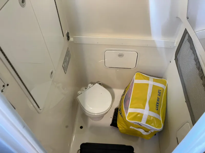 Slide: The Image of 2013 Regulator 28 boat bathroom with toilet and yellow life jacket bag. - 20