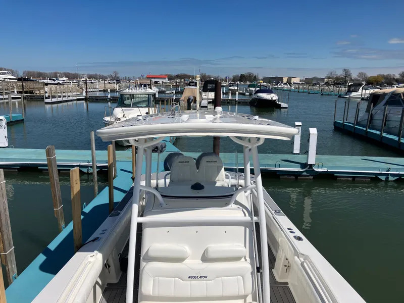 Slide: The Image of 2013 Regulator 28 boat docked in a marina under clear blue skies. - 24