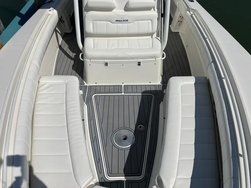 Slide: The Image of 2013 Regulator 28 boat interior with white seating and gray deck flooring. - 25