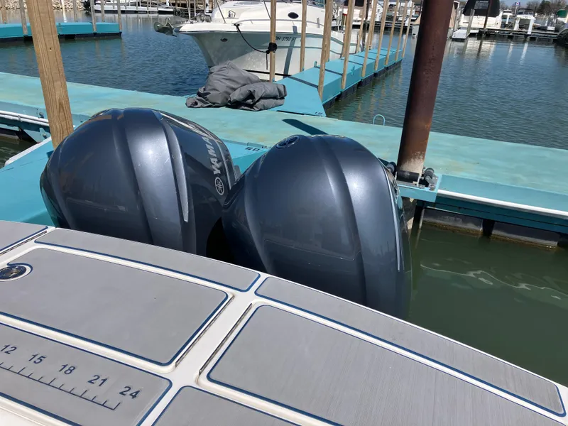 Slide: The Image of 2013 Regulator 28 boat with twin outboard engines docked at a marina. - 3