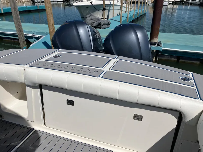 Slide: The Image of 2013 Regulator 28 boat with dual outboard motors at a marina dock. - 34