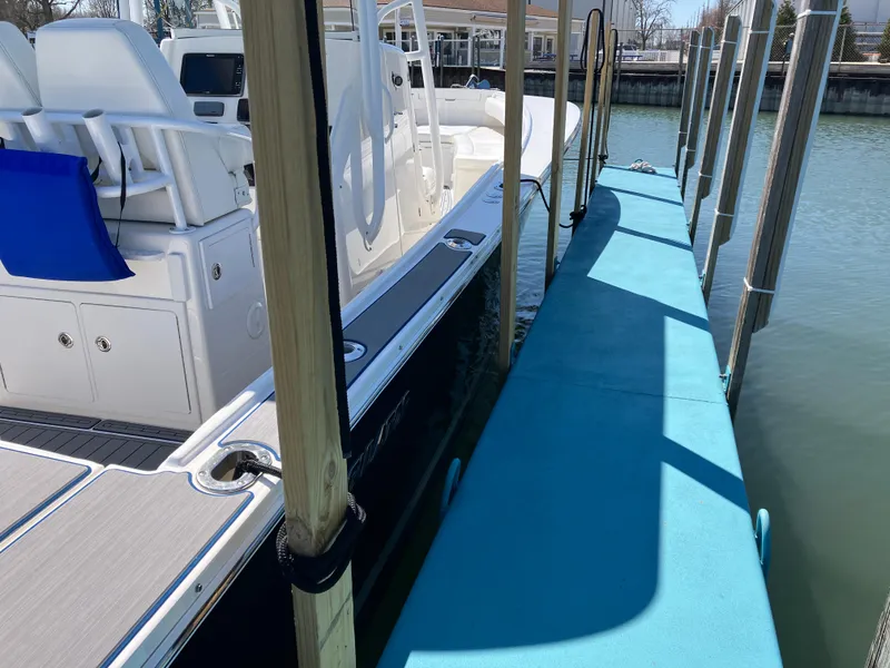 Slide: The Image of 2013 Regulator 28 boat docked beside a blue walkway. - 36