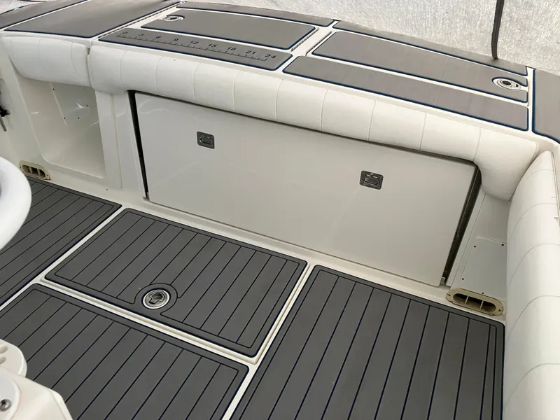 Slide: The Image of 2013 Regulator 28 boat interior with cushioned seating and storage compartments. - 6