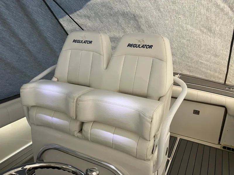 Slide: The Image of 2013 Regulator 28 boat with dual white cushioned seats and branded embroidery. - 7