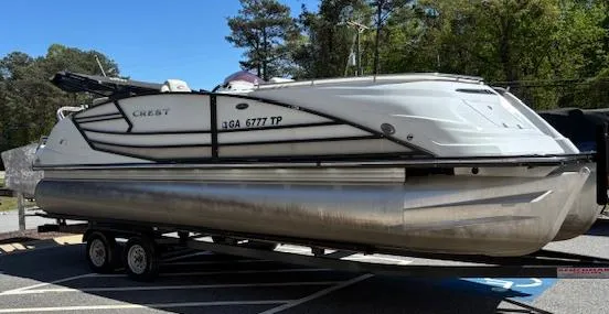 Slide: The Image of 2019 Crest Savannah 250 SLS pontoon boat on trailer, parked outdoors. - 3