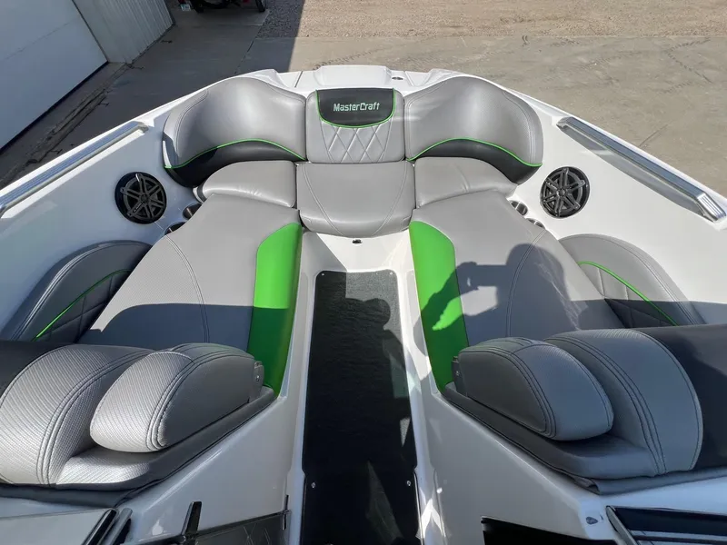 Slide: The Image of 2013 MasterCraft X-25 boat interior with gray and green seating, featuring speakers and stylish design. - 13