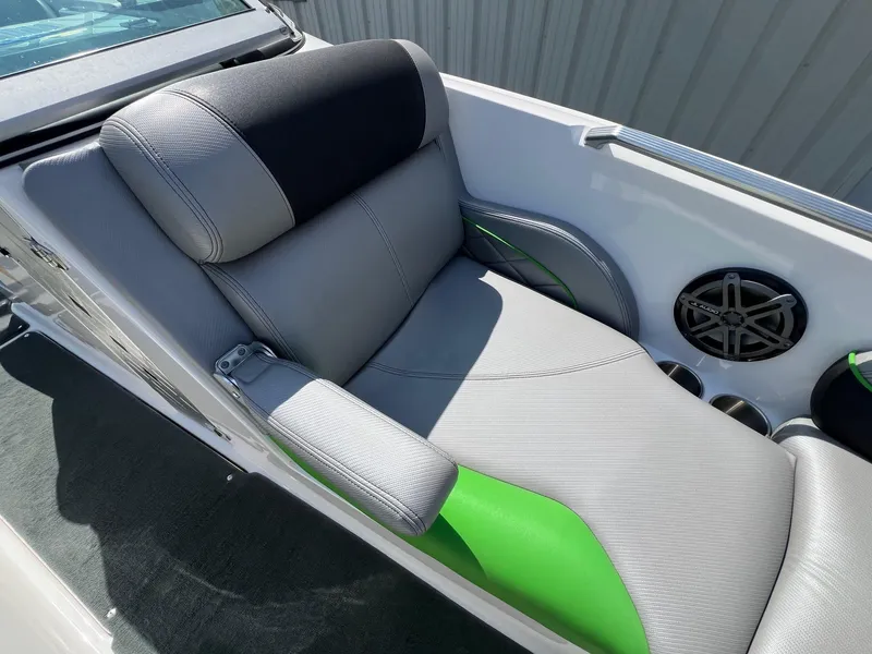 Slide: The Image of 2013 MasterCraft X-25 boat seat with gray and green upholstery, featuring a speaker and cup holders. - 16