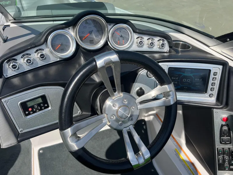 Slide: The Image of Steering wheel and dashboard of a 2013 MasterCraft X-25 boat, featuring gauges and controls. - 21