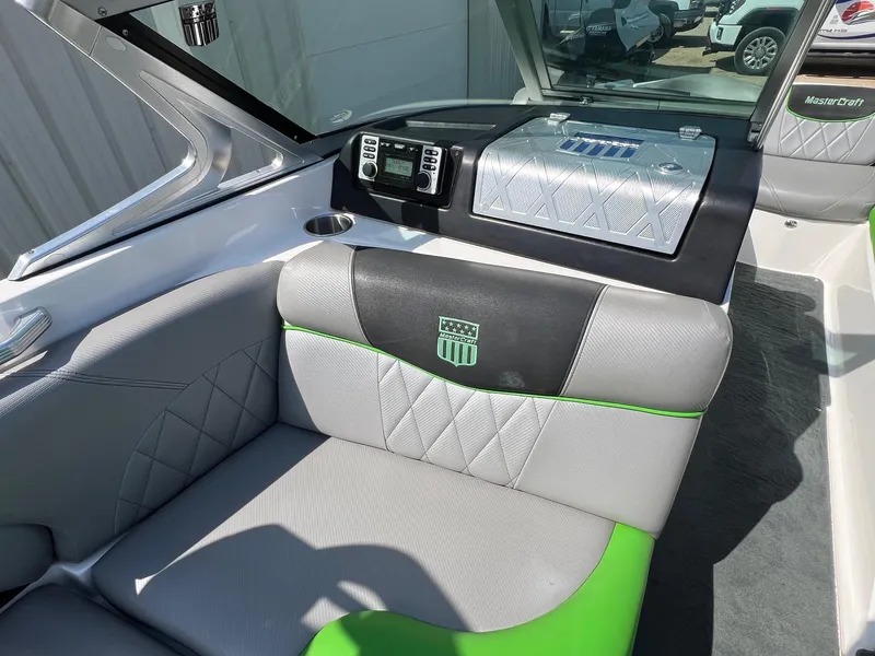 Slide: The Image of 2013 MasterCraft X-25 boat interior with gray and green seating, dashboard, and logo. - 27