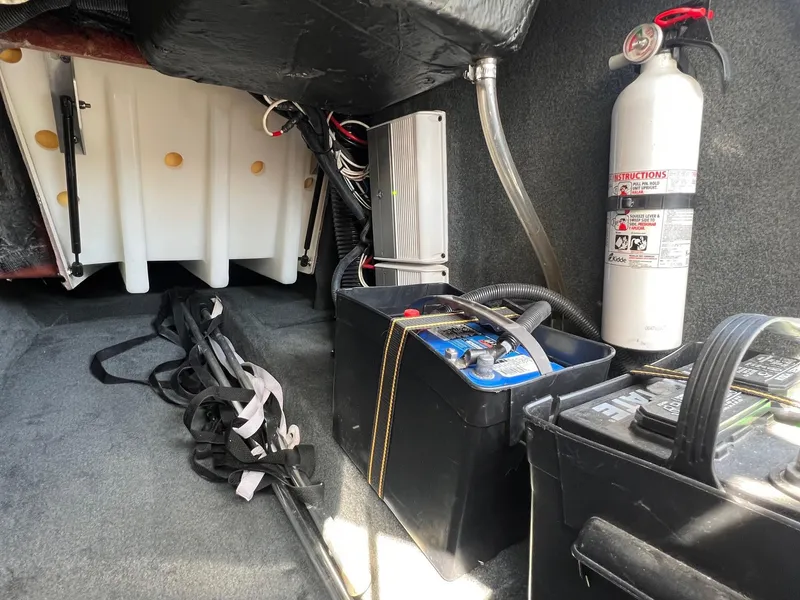 Slide: The Image of 2013 MasterCraft X-25 interior storage with battery, fire extinguisher, and equipment. - 28