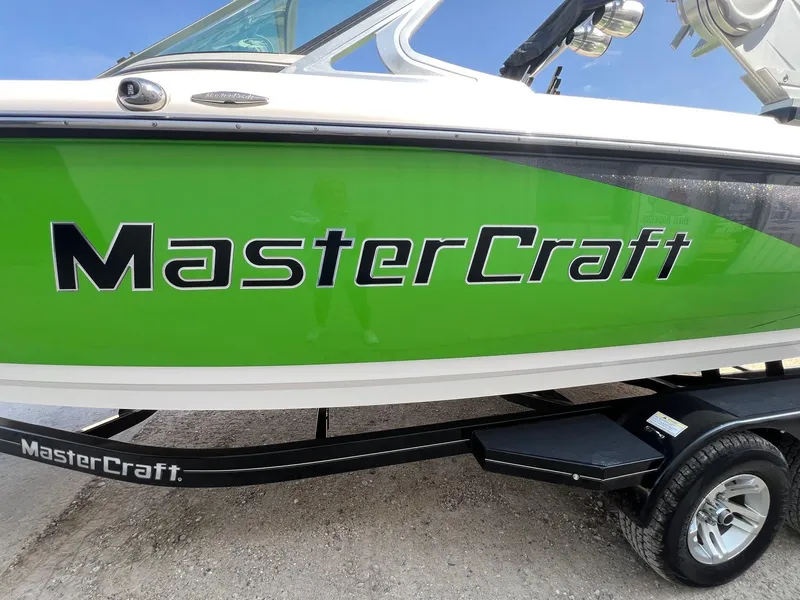 Slide: The Image of 2013 MasterCraft X-25 boat with vibrant green hull and trailer. - 3