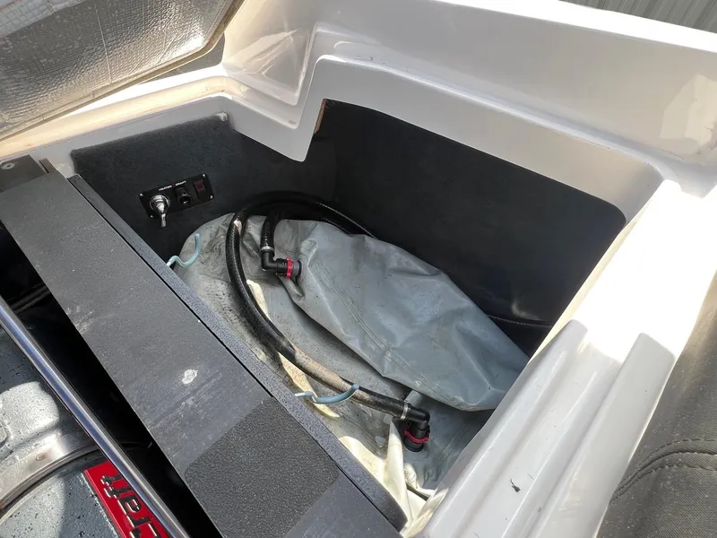 Slide: The Image of 2013 MasterCraft X-25 boat storage compartment with ballast bag and control panel. - 41