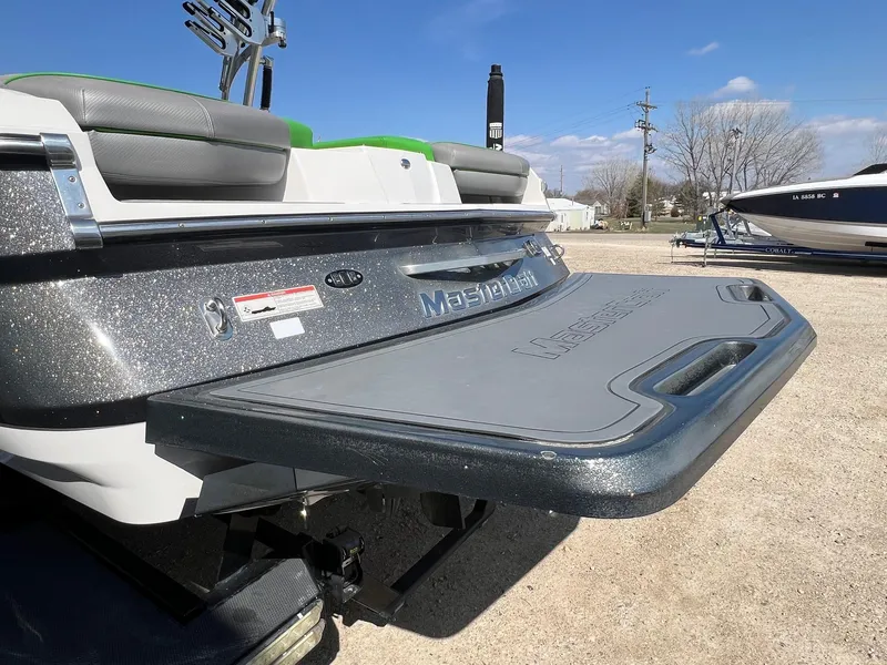 Slide: The Image of 2013 MasterCraft X-25 boat with glitter finish and swim platform, parked outdoors. - 49